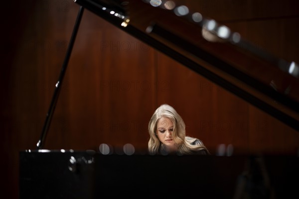 Young woman, pianist, with concentrated facial expression playing on a Steinway & Sons grand piano, Stuttgart, Baden-Württemberg, Germany