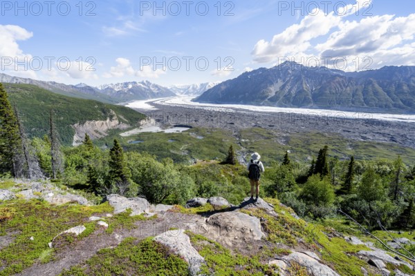 Young man enjoying the view, view of impressive mountain landscape with Matanuska glacier and glaciated mountain peaks, Lion's Head, Chugach Mountains, Alaska, USA