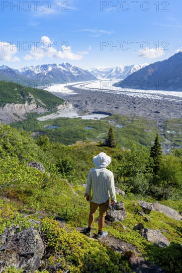 Young man enjoying the view, view of impressive mountain landscape with Matanuska glacier and glaciated mountain peaks, Lion's Head, Chugach Mountains, Alaska, USA