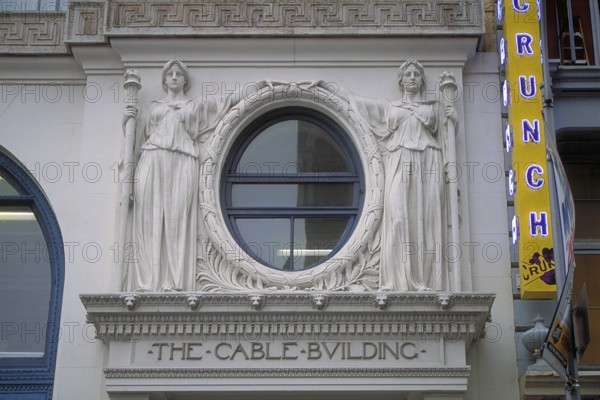 Two female sculptures above the entrance to the historic Cable Building, built in 1894 in Beaux Arts style, 611 Broadway, New York City, USA