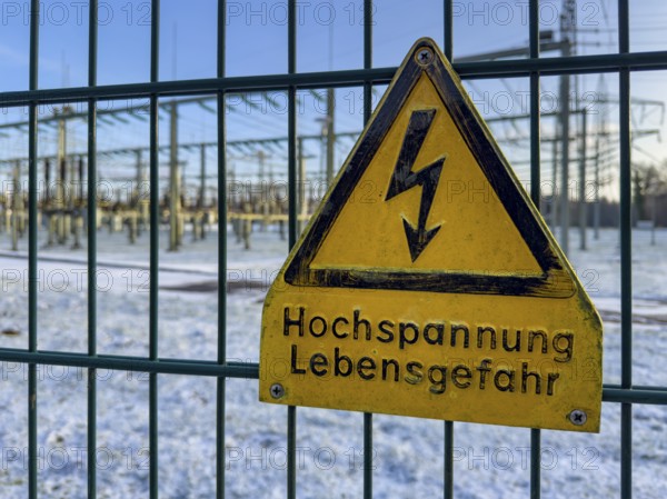 Recording of snow in winter warning sign warning high voltage danger to life on fence from behind substation substation substation substation part of electrical supply network with transformer generator in the background high-voltage lines high-voltage pole for secure energy supply Power supply, Germany