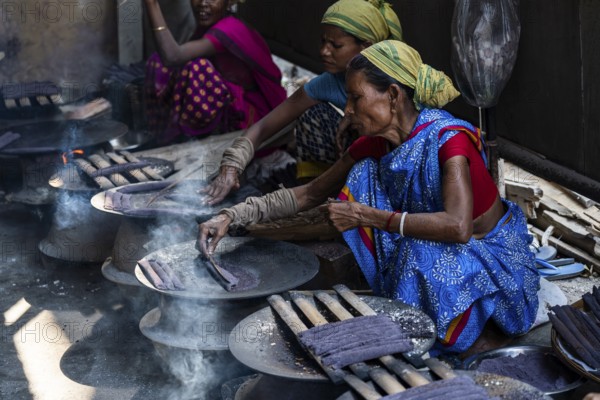 Women prepare 'Pitha', Assamese traditional rice-based sweets or snacks, as part of preparations ahead of the 'Magh Bihu' festival, in Guwahati, Assam, India on January 12, 2026. Magh Bihu, also called Bhogali Bihu, is Assam's harvest festival marking the end of the agricultural season and celebrated with feasts, community bonfires, and traditional food