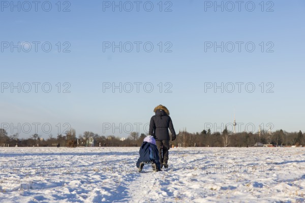 A woman pulls a child on a sled on Tempelhofer Feld in Berlin on 11.01.2026