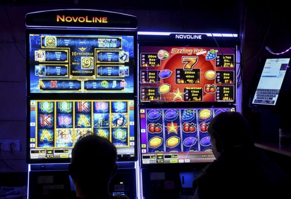 Guests at a pub in front of slot machines, Munich, Bavaria, Germany