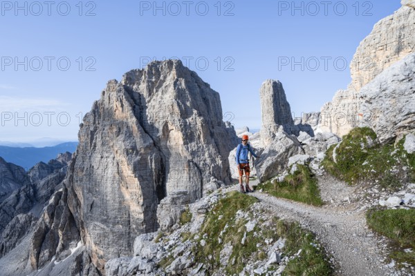 Mountaineers on a hiking trail, Via Ferrata Bocciere Centrale via ferrata, spectacular mountain landscape with steep rocky peaks, Brenta-Adamello Nature Park, Trentino, Italy