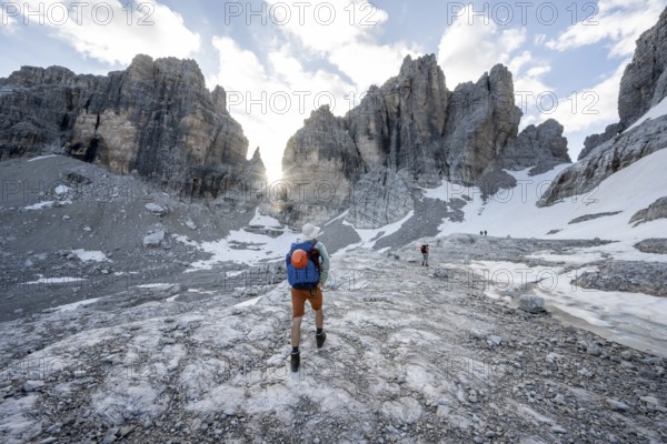 Mountaineers climbing a rocky mountain landscape with steep rock peaks to Bocca degli Armi, Sun Star, Brenta Mountains, Brenta-Adamello Natural Park, Trentino, Italy