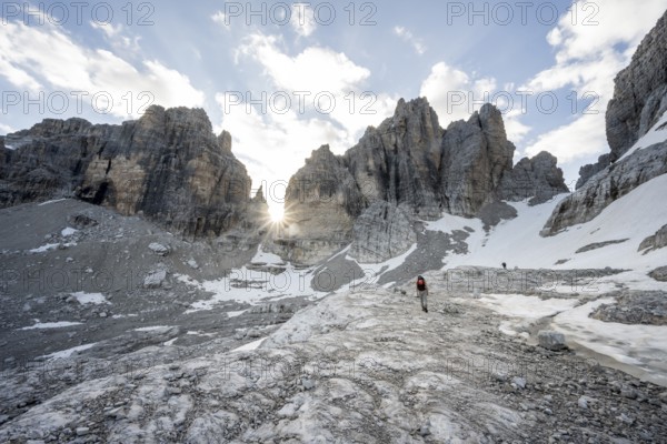 Ascent in a rocky mountain landscape with steep rocky peaks to Bocca degli Armi, Sun Star, Brenta Mountains, Brenta-Adamello Natural Park, Trentino, Italy