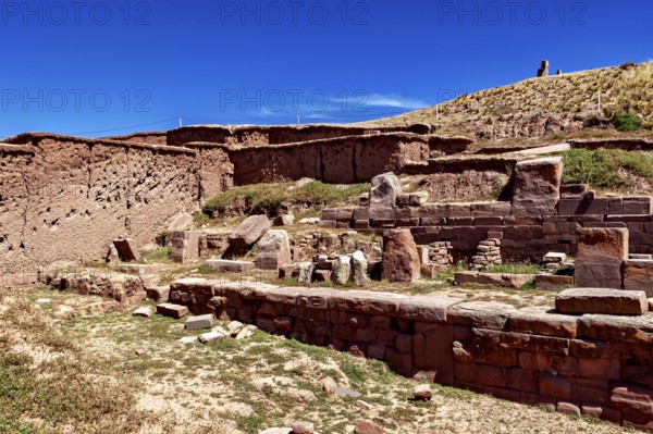 Stone ruins with tiered architecture in a landscape under an open sky, The archaeological site with the ruins of Tiwanaku in Bolivia