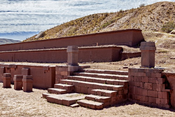 Historic ruins with stairs in a desert landscape under clear skies, The archaeological site with the ruins of Tiwanaku in Bolivia