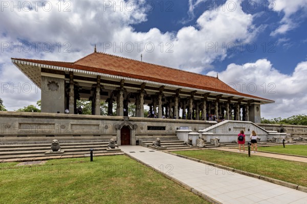 A long building with pillars and a distinctive roof surrounded by lawns on a cloudy day, Colombo Sri Lanka's City Hall