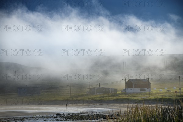 Foggy coastal landscape with scattered houses and quiet atmosphere at dawn, Kiberg, Finnmark, Norway