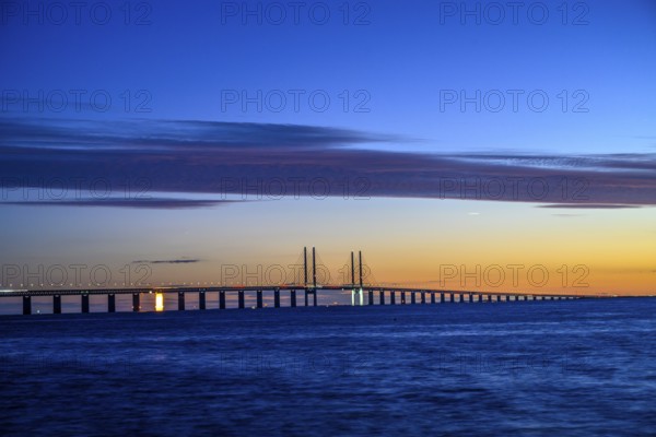 Modern Øresund bridge across the sea at sunset with colorful sky illuminated by a colorful sunset, Malmö, Skane län, Sweden