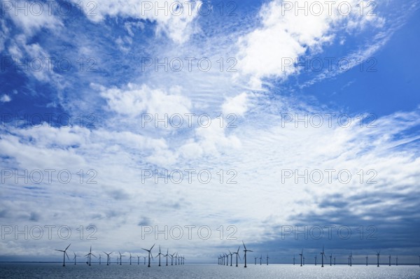 Wide landscape with offshore wind turbines from the Kriegers Flak 2 offshore wind farm under a blue sky, Øresund, Denmark