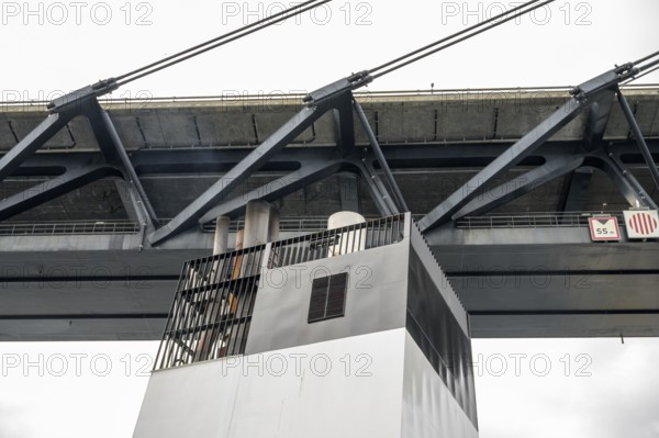 Bottom view of a metal Øresund bridge structure and a ship chimney, bridge at dusk with bright sky and calm water, Malmö, Øresund, Skane län, Sweden