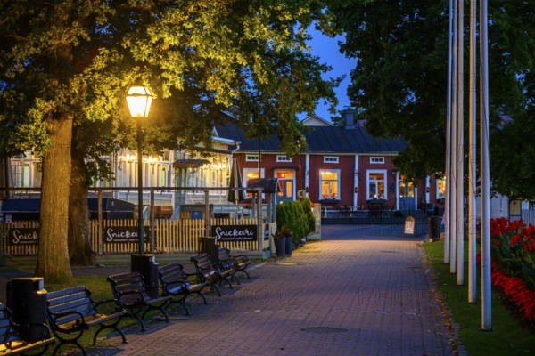 Illuminated alley in the old town of Naantali with benches and trees at dusk, cozy atmosphere, Naanatali, Varsinais-Suomi, Finland