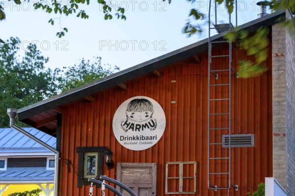 Street scene in the old town of Naantali, wooden cabin with humorous bar sign at dusk, surrounded by trees, Naanatali, Varsinais-Suomi, Finland