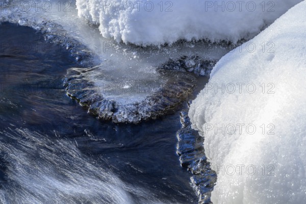 Ilsenburg, Saxony-Anhalt, Germany, detailed view of ice and snow on a flowing body of water on the Ilse river in the Harz National Park on the Heinrich-Heine trail Ilsetal