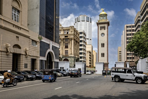Urban street full of vehicles surrounded by modern and historic buildings under blue skies, The roads of Colombo Sri Lanka
