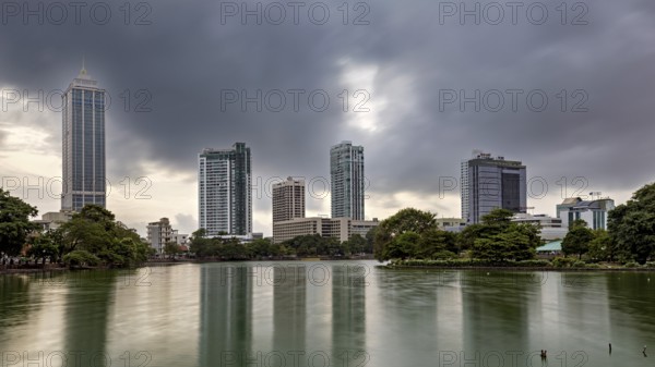 Cityscape with skyscrapers and a lake under a cloudy sky, the skyline of Colombo Sri Lanka at night