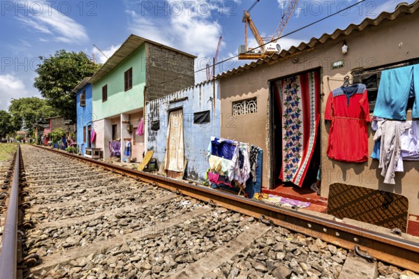 Colourful houses along railroad tracks with clothes hung up in an urban setting, railway line in the historic Slave Island district of Colombo Sri Lanka