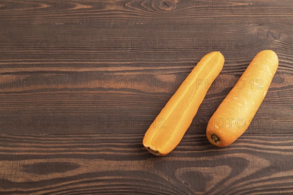 Orange Carrot on brown wooden background. Side view, copy space. healthy food, vegetable, minimalism