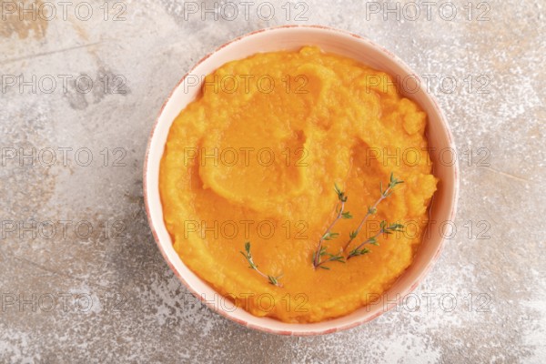 Sweet potato porridge in ceramic bowl on brown concrete background. Diet, healthy eating concept. top view, flat lay, close up