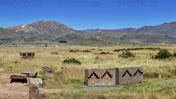 View of vast mountain landscape with stones and geometric patterns against a picturesque sky, The archaeological site with the ruins of Tiwanaku in Bolivia