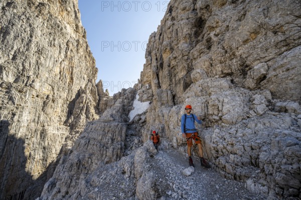 Two mountaineers on the Via Ferrata Bocciere Centrale via ferrata, spectacular mountain landscape with steep rock faces, Brenta Mountains, Parco Naturale Brenta-Adamello, Trentino, Italy