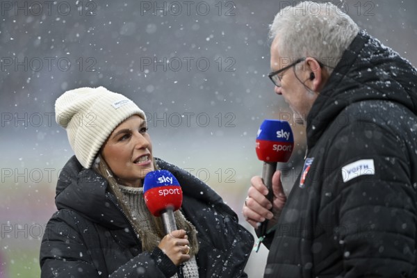 SKY reporter presenter Mara Mones wears cap in interview microphone micro logo with CEO managing director Holger Sanwald 1. FC Heidenheim 1846 FCH portrait snow, blowing snow, winter, Voith-Arena, Heidenheim, Baden-Württemberg, Germany