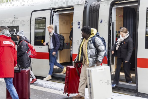 Winter in Stuttgart. There is also a closed layer of snow in the main train station. Travelers with suitcases disembarking from an ICE. Stuttgart, Baden-Württemberg, Germany