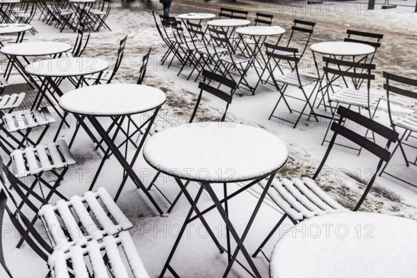 Winter in Stuttgart. Outdoor dining chairs and tables are covered with snow. Geometric structures. Stuttgart, Baden-Württemberg, Germany