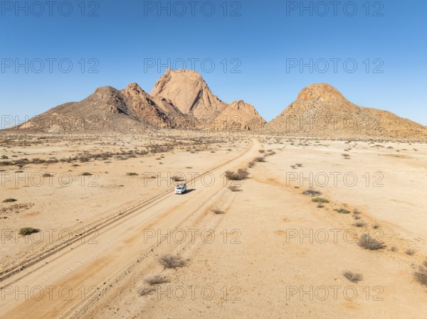 Car on sandy road, mountains in the desert, Spitzkoppe summit, Namib desert, Namibia