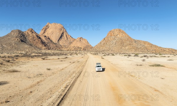 Aerial view, car on sandy road, mountains in the desert, Spitzkoppe summit, Namib desert, Namibia