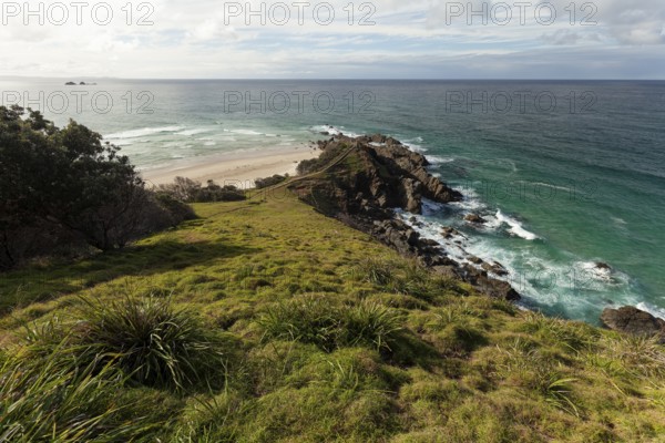 Sunlit daytime view with lookout platform below and glowing cliffs at Cape Byron, New South Wales, Australia