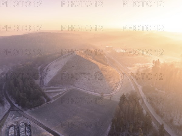 Snowy hill in soft morning light, surrounded by fog, old deposit, construction site for PV open space system, Lindenrain, Calw, Germany