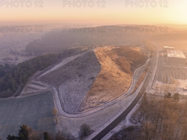 Hillside area at sunset with golden light and snowy paths, old deposit, construction site for PV open space system, Lindenrain, Calw, Germany