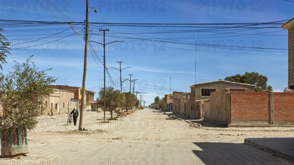 Empty street in a quiet area with power lines and few buildings, the city of Uyuni in Bolivia