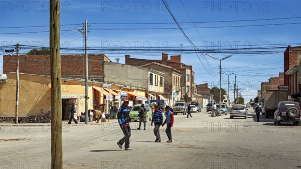 Lively street scene in a small town with passers-by and cars, the city of Uyuni in Bolivia