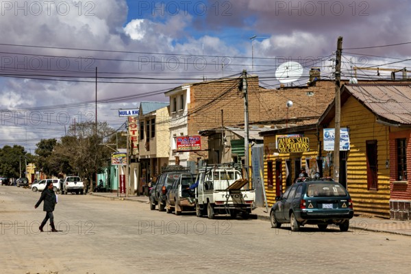 Street scene with parked cars and clouds in the sky in a small town, the town of Uyuni in Bolivia
