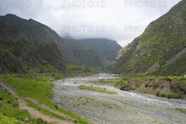 Wide valley with a river surrounded by imposing green mountains with clouds, Tergi River, Terek, Darial Gorge, Dariel Gorge, Kazbegi, Stepansminda, Georgian Military Highway, Mtskheta-Mtianeti Province, High Caucasus, Georgia