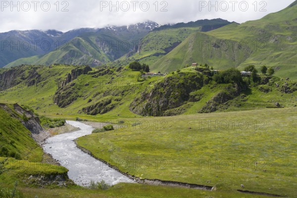 Peaceful green landscape with a river nestled in a wide valley surrounded by mountains, landscape near Sioni, Tergi River, Terek, Georgian Military Highway, Mtskheta-Mtianeti Province, High Caucasus, Georgia