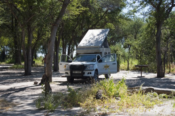 Motorhome on a shady woodland surrounded by trees and sunshine, 4WD motorhome, camper, bushcamper, Botswana