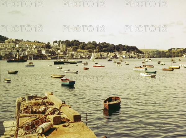 Boats at moorings in harbour of town Fowey, Cornwall, England, UK view across River Fowey estuary from Polruan, 1960s