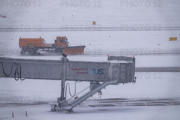 The onset of winter in North Rhine-Westphalia, flight operations are maintained at Düsseldorf airport with great effort, taxiways, runway are freed from snow and ice with many clearing vehicles, airplanes are de-iced in front of takeoff, North Rhine-Westphalia, Germany