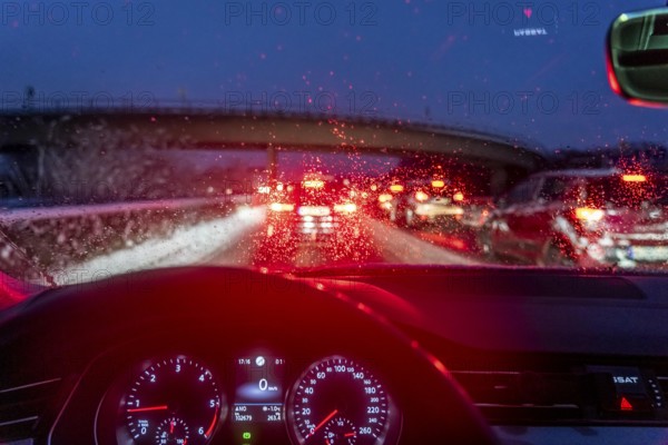 Driving in winter, in snow, motorway, rear lights, brake lights, speedometer, cockpit