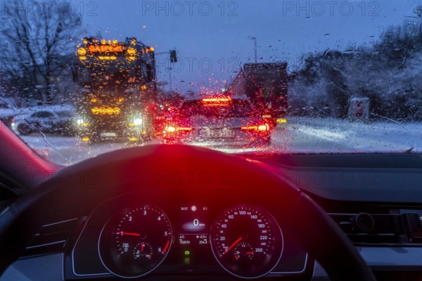 Driving in winter, in snow, rain, rear lights, brake lights, speedometer, cockpit