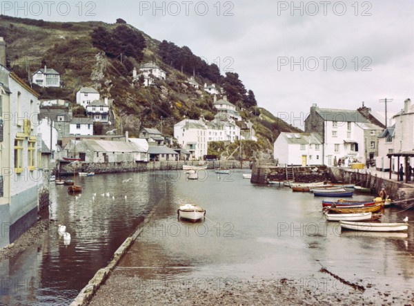 Historic waterfront buildings around the harbour river mouth of the River Pol at village of Polperro, Cornwall, England, UK