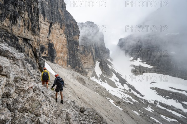 Two mountaineers descending to Rifugio Alimonta, Brenta Mountains, Trentino, Italy