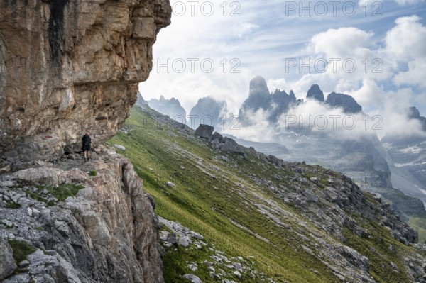 Mountaineers on a trail in front of picturesque mountain landscape with rocky peaks, Via Ferrata SOSAT via ferrata, Cima Tosa summit in the back, Brenta Mountains, Trentino, Italy