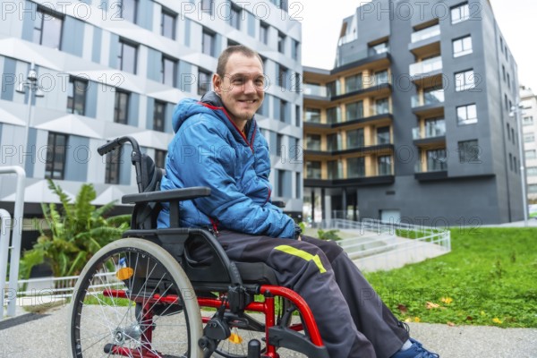 Smiling man with a disability navigating a modern urban environment in his wheelchair, highlighting themes of inclusion, accessibility, and independent living